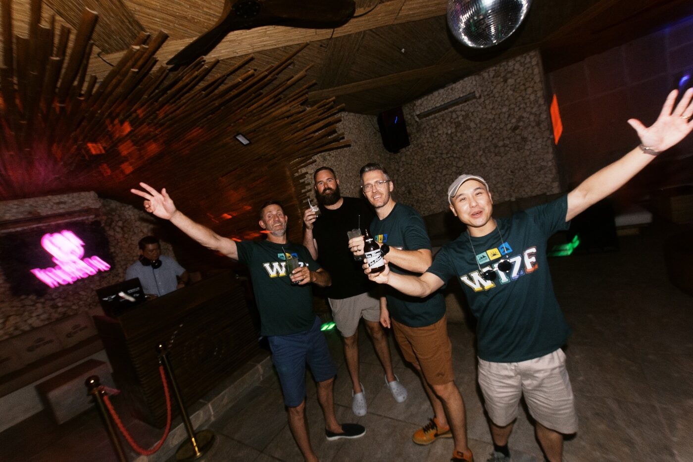 Friends raising their drinks and cheering at an evening event