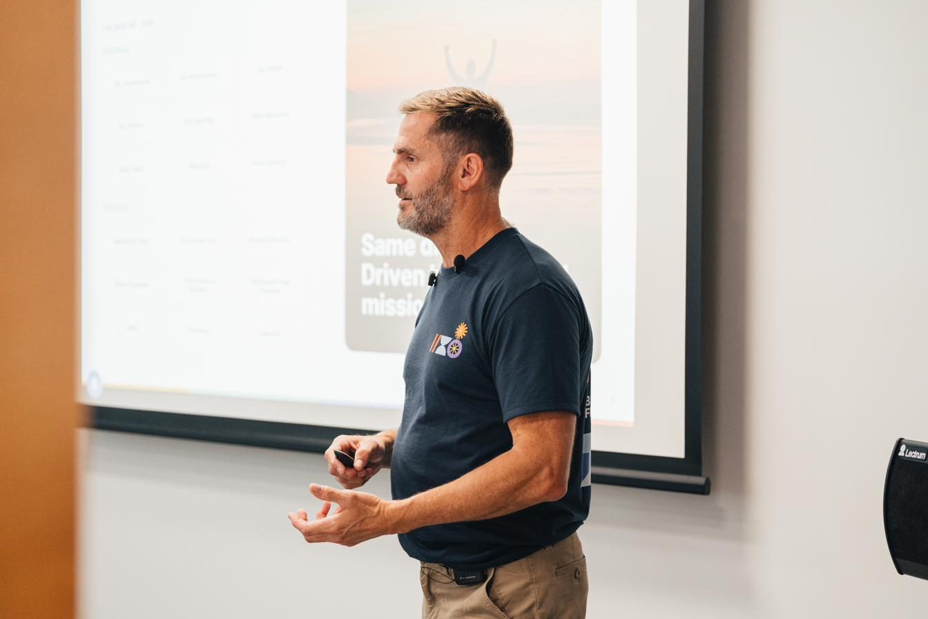 Jamie speaking in front of a screen